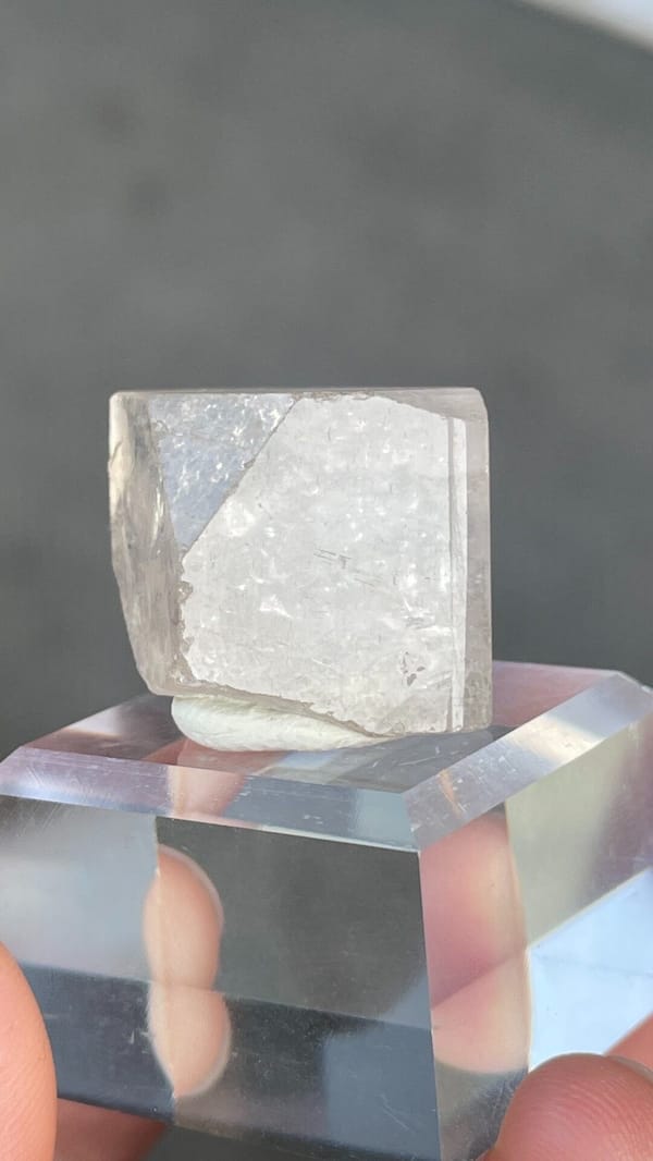 Colourless blocky topaz crystal from Yunnan, China, on an acrylic stand, second angle