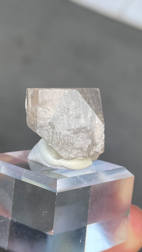 Colourless blocky topaz crystal from Yunnan, China, on an acrylic stand, close-up of the crystal faces