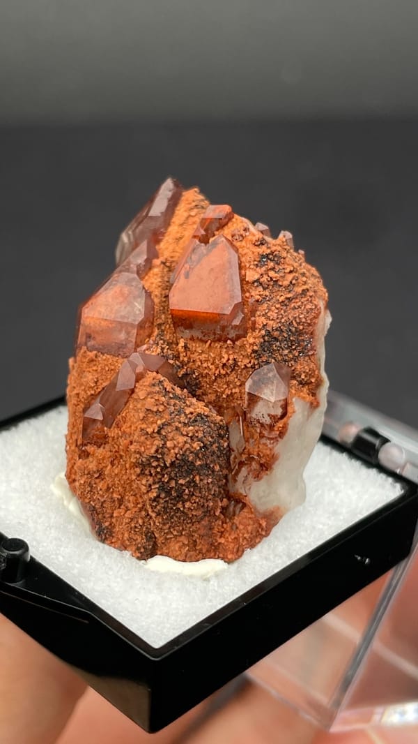 Red hematoid quartz with black specular hematite from Shanxi, China, in a perky box, reverse side