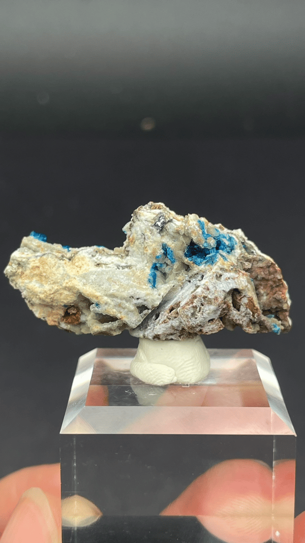 Deep blue veszelyite fan on cream matrix from Yunnan, China, on an acrylic stand, detail of the matrix contact