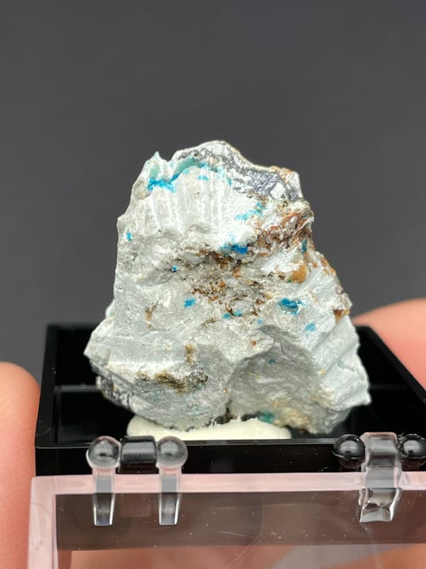 Electric blue veszelyite crust on pale matrix from Yunnan, China, in a display box, top view