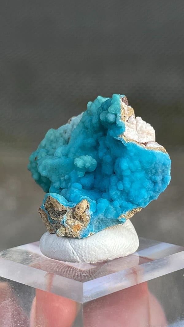 Turquoise botryoidal hemimorphite crust from Yunnan, China, on an acrylic stand, close-up of the crystal faces
