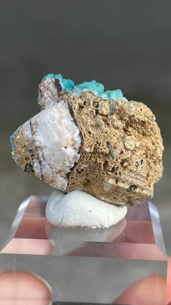 Turquoise botryoidal hemimorphite crust from Yunnan, China, on an acrylic stand, detail of the matrix contact