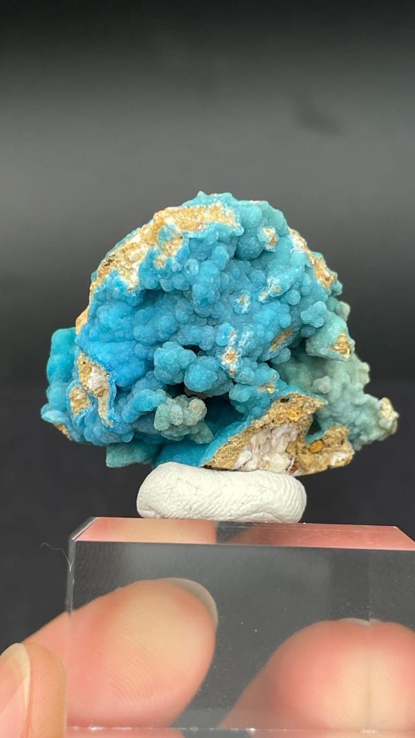 Turquoise botryoidal hemimorphite crust from Yunnan, China, on an acrylic stand, close-up of the crystal faces