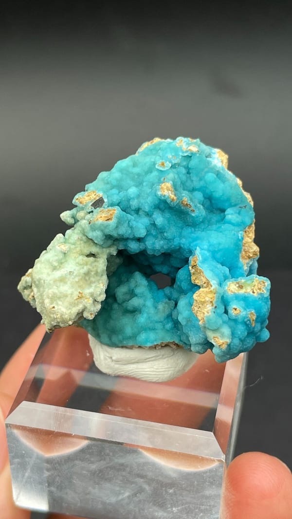 Turquoise botryoidal hemimorphite crust from Yunnan, China, on an acrylic stand, detail of the matrix contact