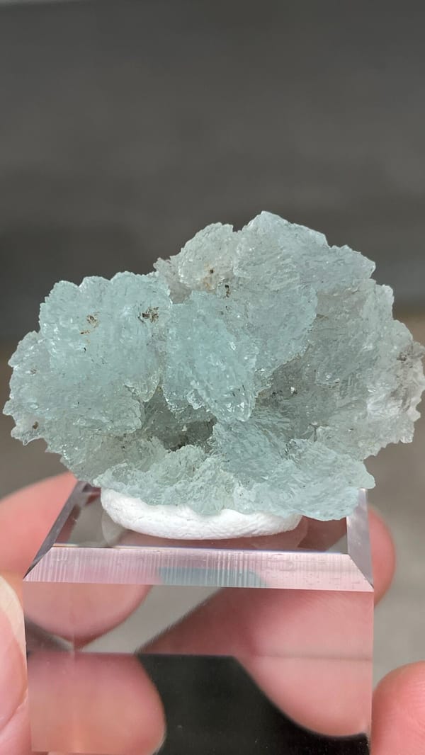 Pale blue bladed hemimorphite crust from Yunnan, China, on an acrylic stand, close-up of the crystal faces