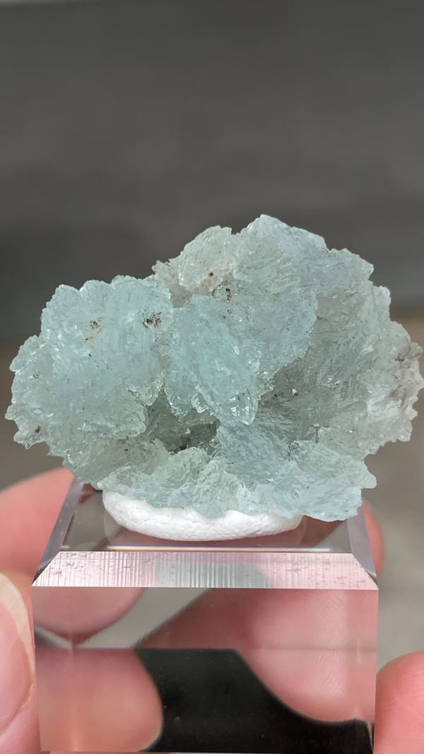 Pale blue bladed hemimorphite crust from Yunnan, China, on an acrylic stand, reverse side