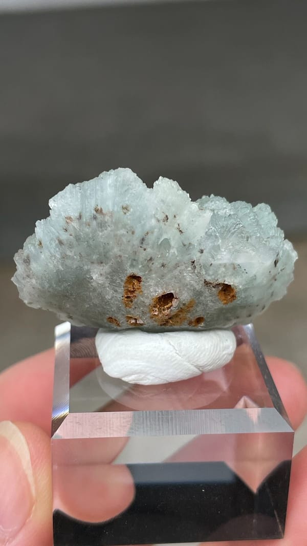 Pale blue bladed hemimorphite crust from Yunnan, China, on an acrylic stand, detail of the matrix contact