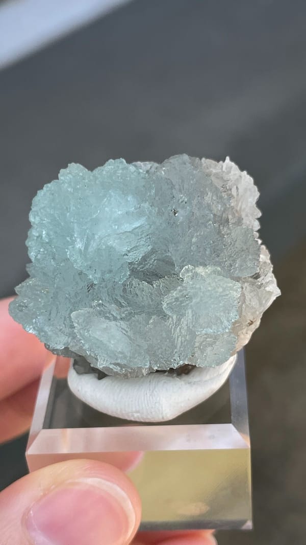 Pale blue hemimorphite fan from Yunnan, China, on an acrylic stand, close-up of the crystal faces