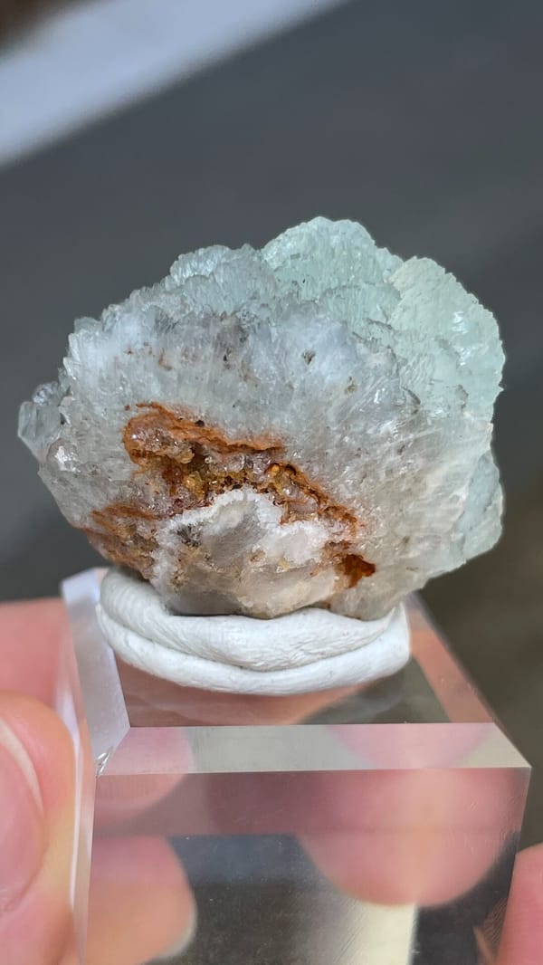 Pale blue hemimorphite fan from Yunnan, China, on an acrylic stand, detail of the matrix contact