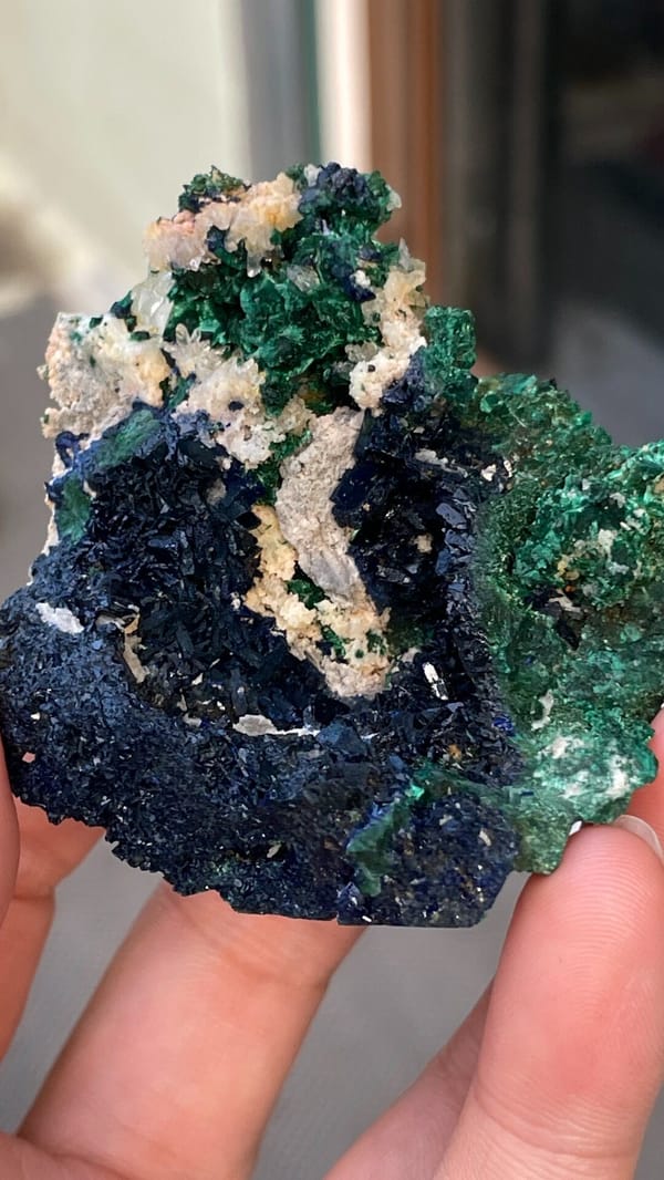 Deep blue azurite with green malachite pocket from Anhui, China, held in hand