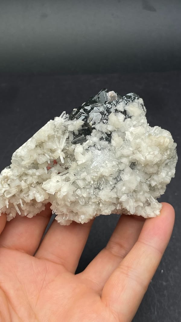 White quartz crust over dark marmatite sphalerite from Peru, close-up of the crystal faces