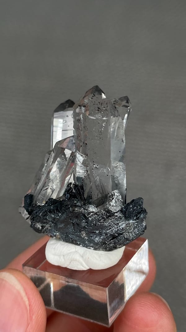 Clear quartz points on black specular hematite from Guangdong, China, close-up of the crystal faces
