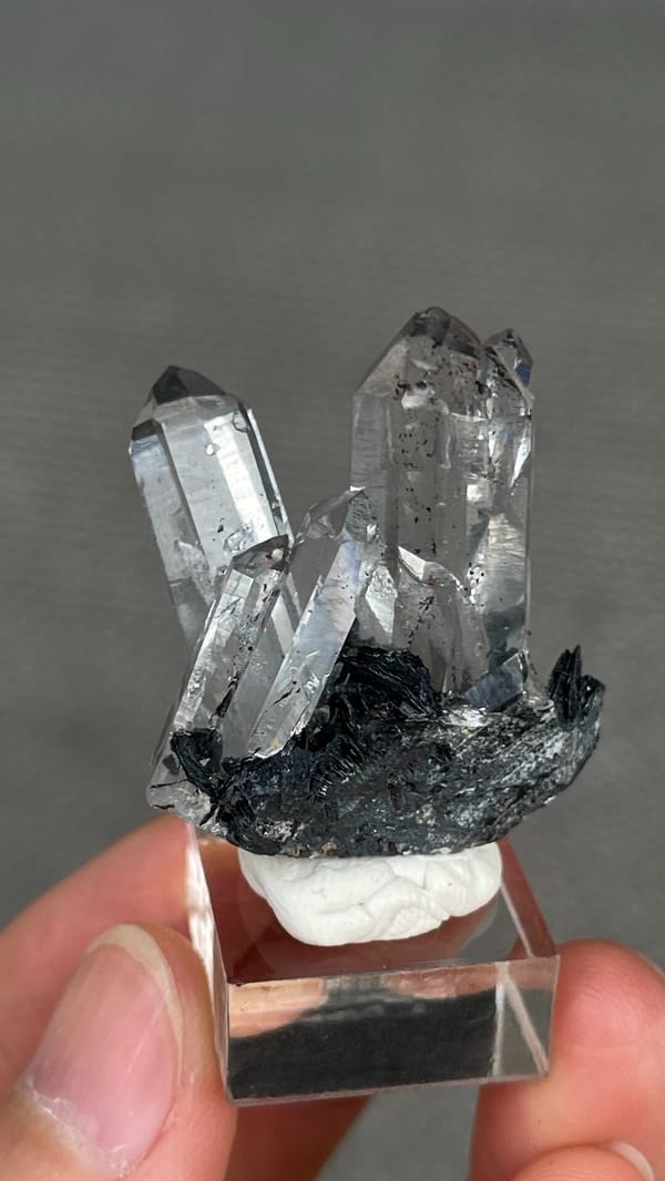 Clear quartz points on black specular hematite from Guangdong, China, detail of the matrix contact
