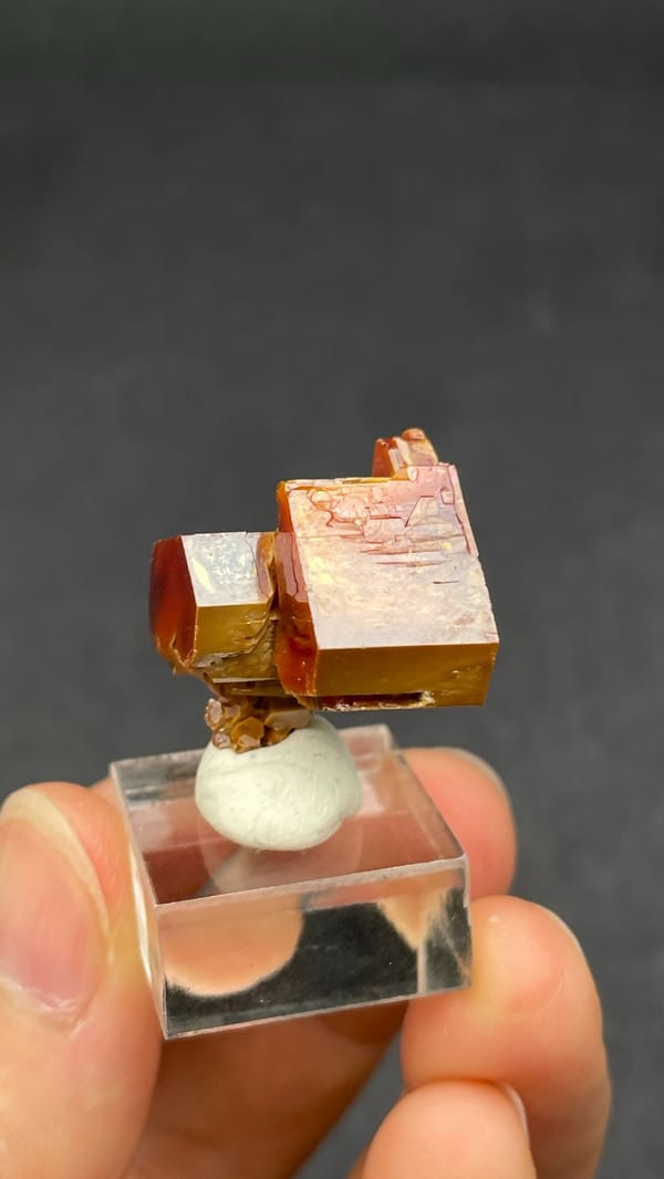 Dark red vanadinite crystal group from Morocco, on an acrylic stand, close-up of the crystal faces