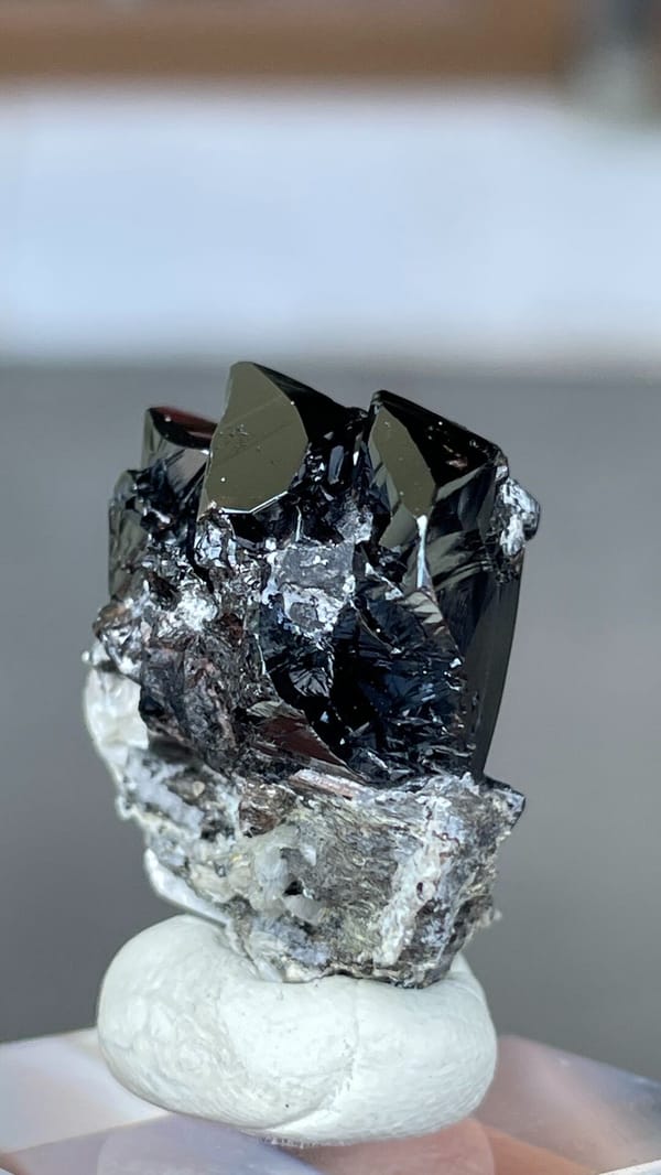 Black lustrous cassiterite crystal group on white matrix from Xuebaoding, Sichuan, close-up of the crystal faces