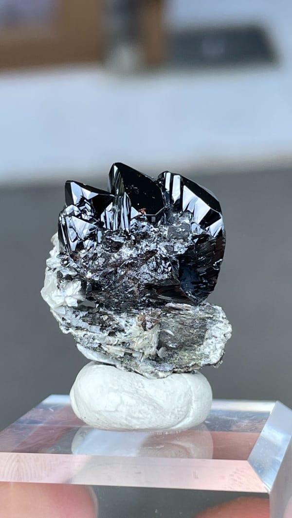 Black lustrous cassiterite crystal group on white matrix from Xuebaoding, Sichuan, detail of the matrix contact