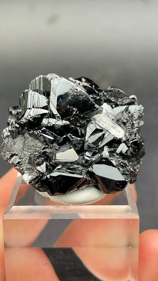 Black lustrous cassiterite with a clear quartz crystal from Xuebaoding, Sichuan, reverse side