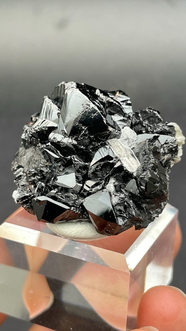 Black lustrous cassiterite with a clear quartz crystal from Xuebaoding, Sichuan, top view