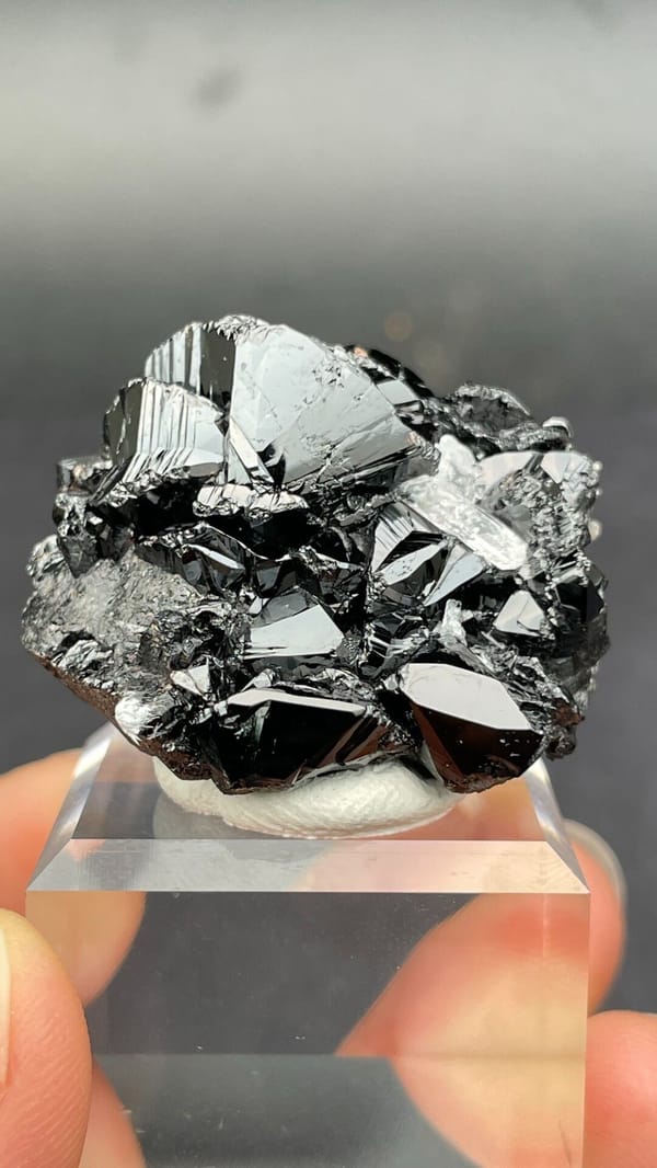 Black lustrous cassiterite with a clear quartz crystal from Xuebaoding, Sichuan, close-up of terminations