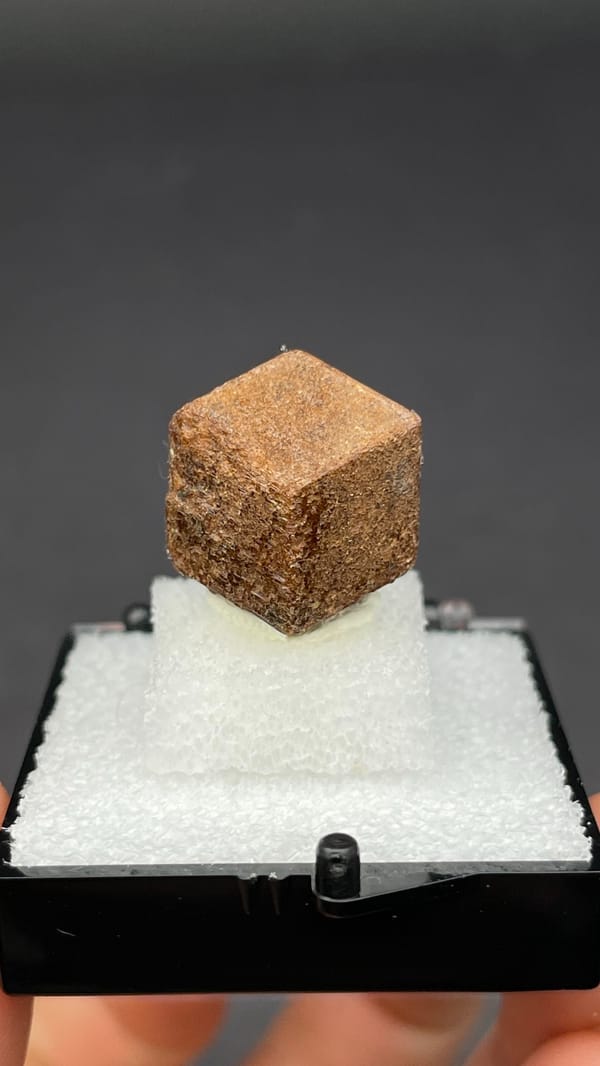 Brown dodecahedral andradite garnet single crystal from Handan, Hebei, China, detail of the matrix contact