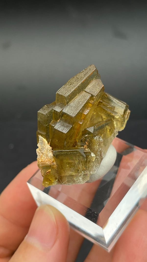 Amber-yellow tabular baryte crystals from Peru, on an acrylic stand, close-up of the crystal faces