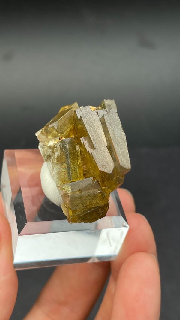 Amber-yellow tabular baryte crystals from Peru, on an acrylic stand, reverse side