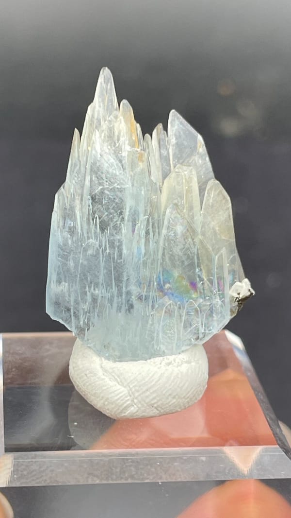 Pale blue transparent baryte blades from Morocco, on an acrylic stand, close-up of the crystal faces