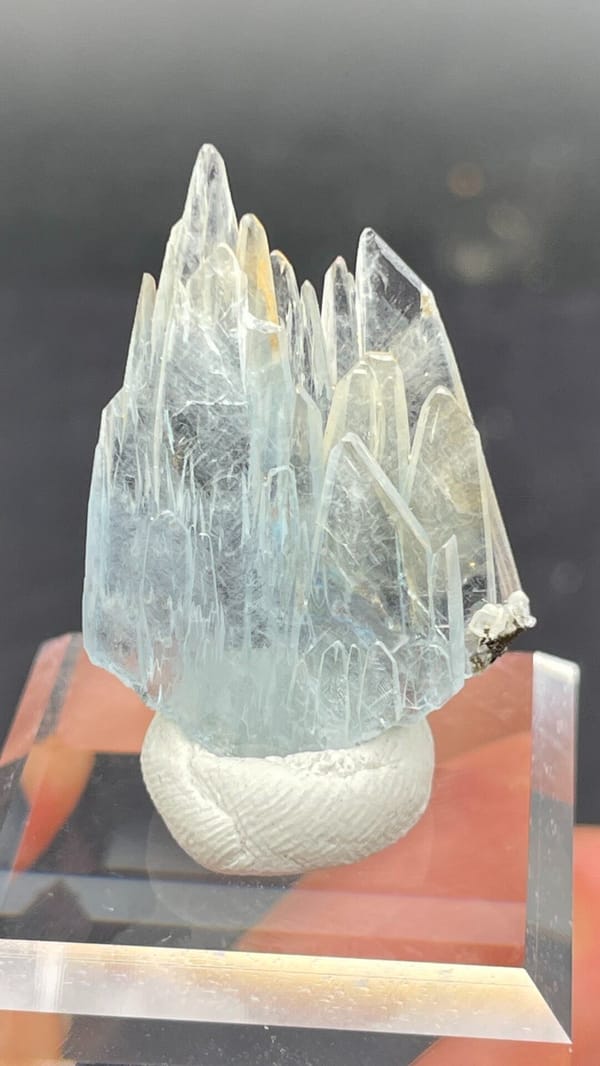 Pale blue transparent baryte blades from Morocco, on an acrylic stand, reverse side