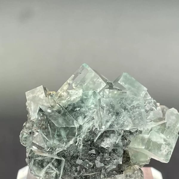 Clear apple-green fluorite cubes with dark inclusions from Hunan — complete view