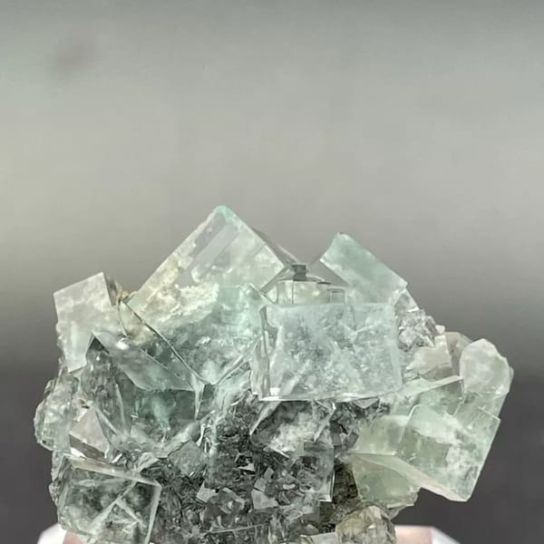 Clear apple-green fluorite cubes with dark inclusions from Hunan — alternate view