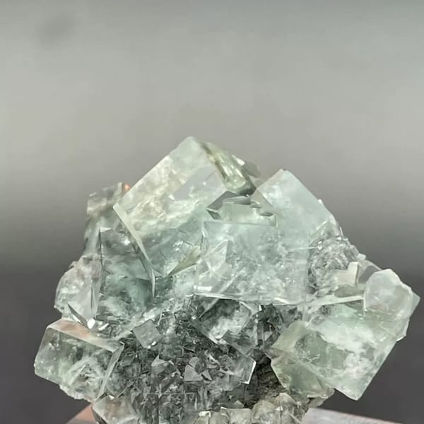 Clear apple-green fluorite cubes with dark inclusions from Hunan — alternate view