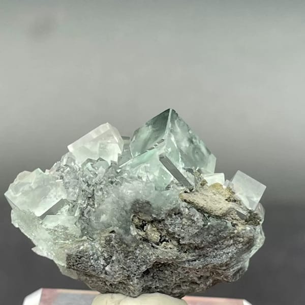Clear apple-green fluorite cubes with dark inclusions from Hunan — detail view