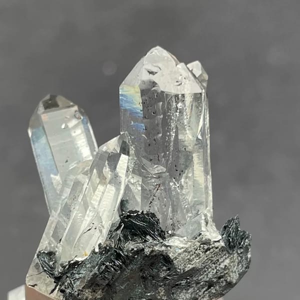 Water-clear quartz points on black specular hematite from Guangdong — complete view