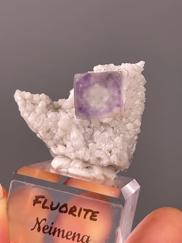 Purple phantom fluorite specimen from Inner Mongolia, China highlighting purple zoned cube on white matrix