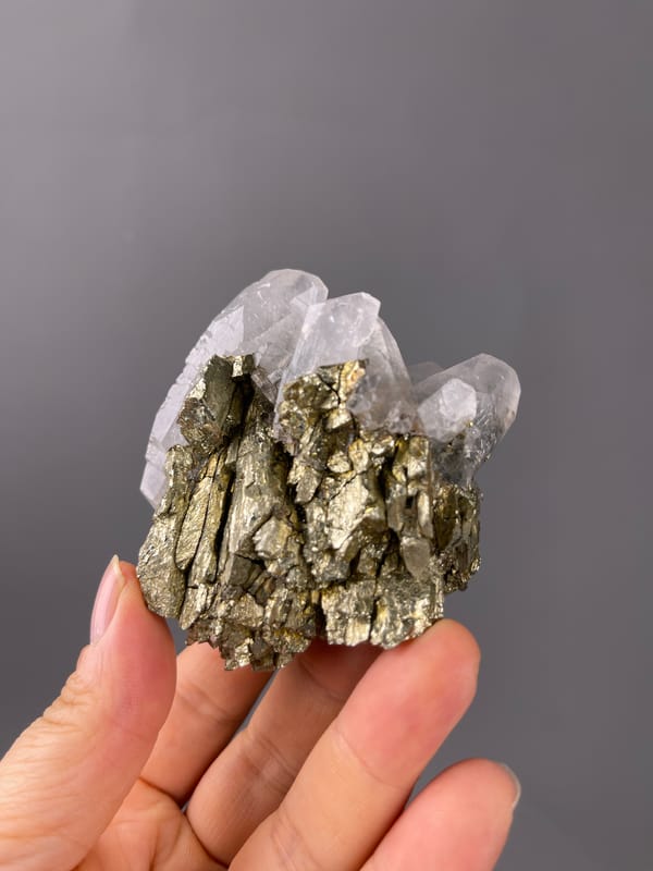 Pyrite specimen defined by visible brassy crystals beside clear quartz