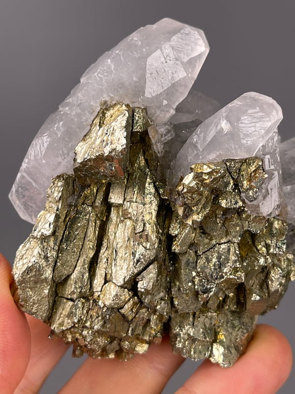 Pyrite specimen characterized by brassy crystals beside clear quartz visibly