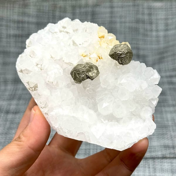 Two pyritohedral pyrite crystals on white quartz druse from Guangxi, China, view 2 of 12