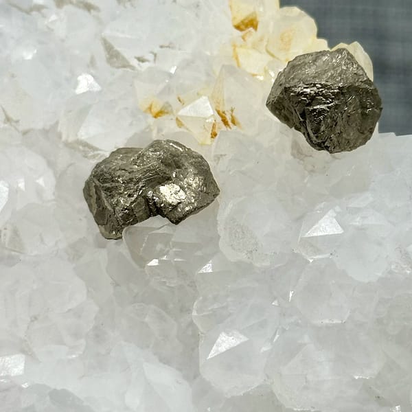 Two pyritohedral pyrite crystals on white quartz druse from Guangxi, China, view 3 of 12