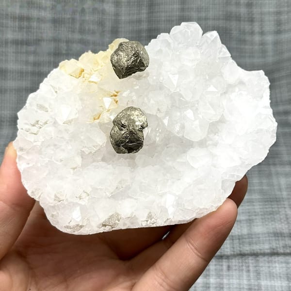 Two pyritohedral pyrite crystals on white quartz druse from Guangxi, China, view 6 of 12