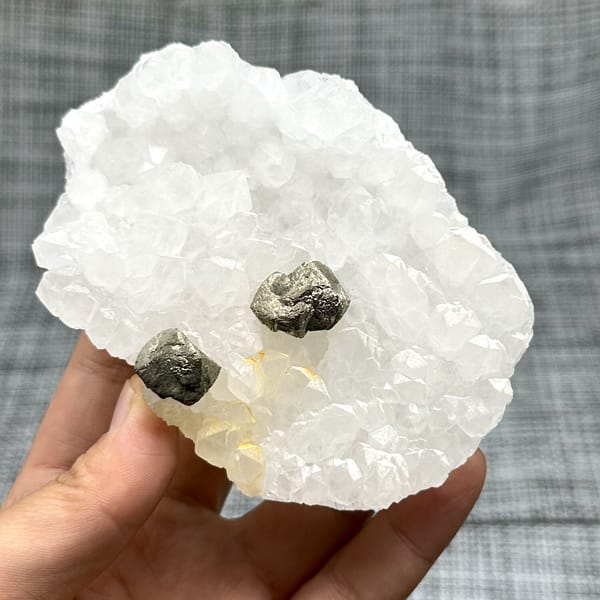 Two pyritohedral pyrite crystals on white quartz druse from Guangxi, China, view 7 of 12