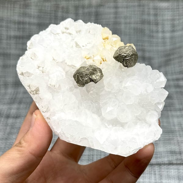 Two pyritohedral pyrite crystals on white quartz druse from Guangxi, China, view 8 of 12