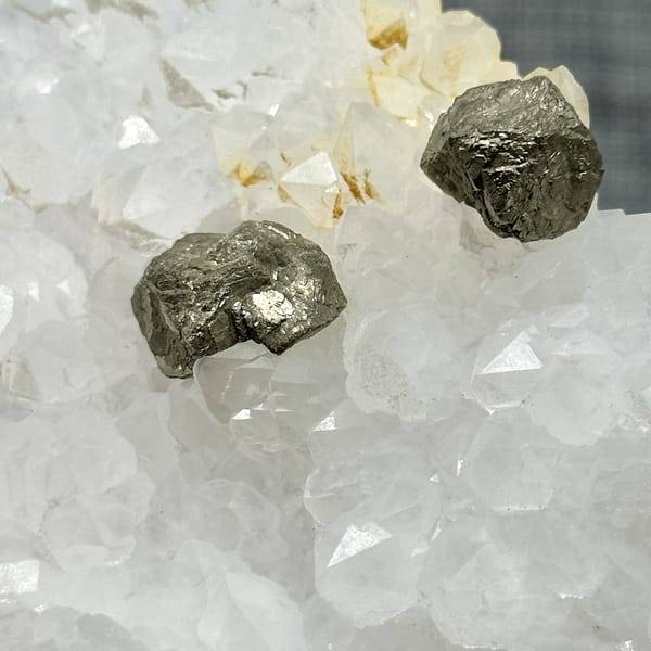 Two pyritohedral pyrite crystals on white quartz druse from Guangxi, China, view 9 of 12