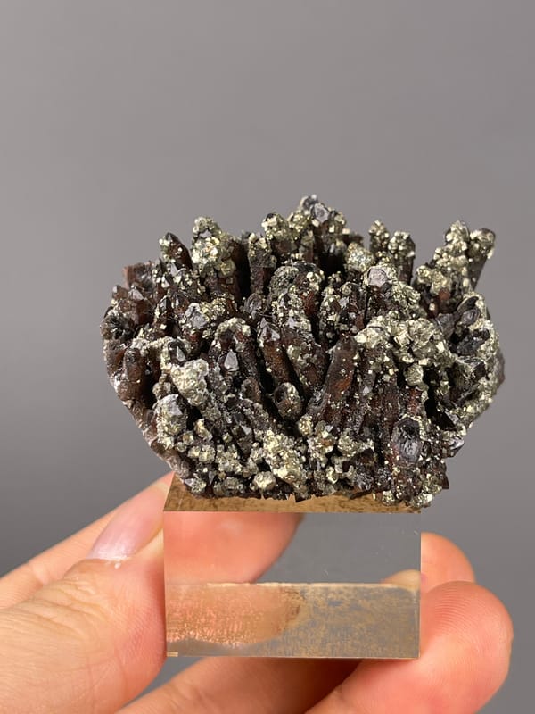 Red quartz specimen from Xianghualing, Hunan, China featuring dark quartz prisms with brassy pyrite