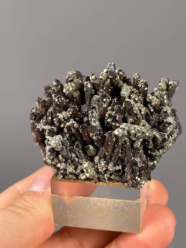 Red quartz specimen from Xianghualing, Hunan, China, defined by dark quartz prisms with brassy pyrite