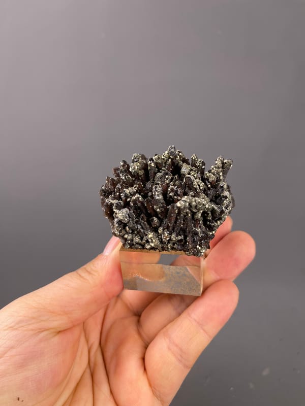 Red quartz specimen from Xianghualing, Hunan, China, characterized by dark quartz prisms with brassy pyrite