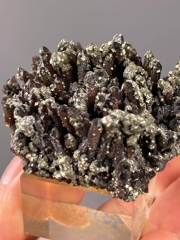 Red quartz specimen from Xianghualing, Hunan, China bearing dark quartz prisms with brassy pyrite