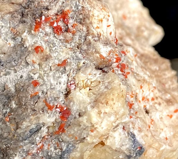 Red wulfenite spots over pale matrix block from Sichuan, China, view 3 of 9