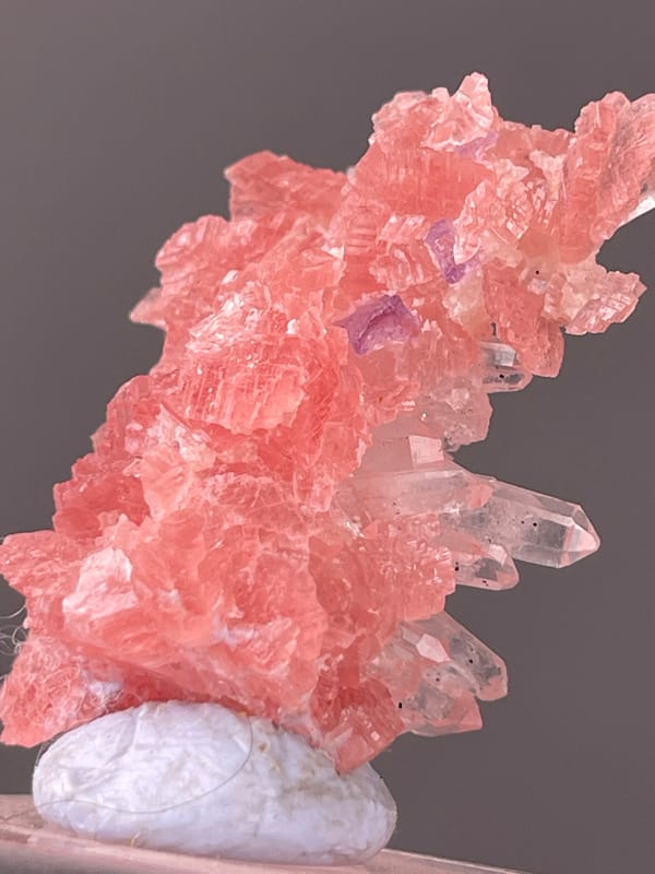 Pink carbonate cluster with clear quartz visible on rhodochrosite specimen from Guangxi, China