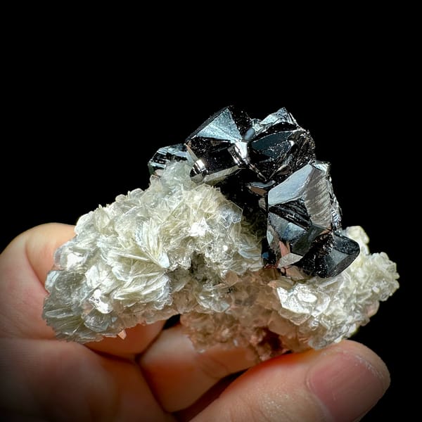 Row of mirror-black cassiterite crystals on muscovite from Xuebaoding, Sichuan, China, second angle